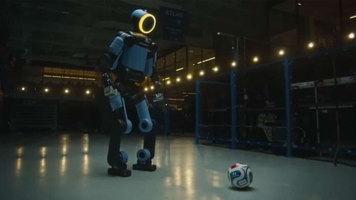 Boston-Dynamics-x-Hyundai-Atlas-robot-FIFA-World-Cup-2026.jpg Το ρομπότ Atlas παρακολουθεί αγώνα σε γιγαντιαία οθόνη — Atlas μαθαίνει ποδόσφαιρο και εξασκείται στο γήπεδο