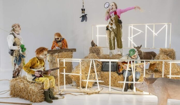 Farm-Fatale.jpg Σκηνή παράστασης με καλλιτέχνες και θεατές σε θέατρο, αφίσα του 7ο Φεστιβάλ Δάσους με σκηνικές φιγούρες