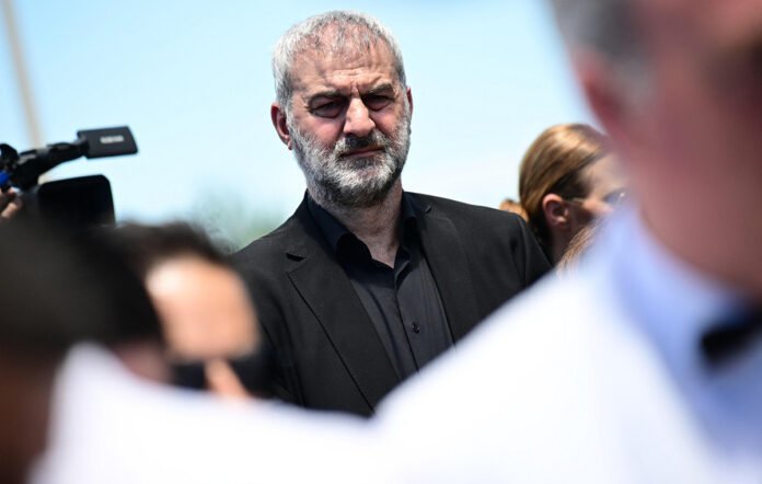 Τραϊανός Δέλλας συγκινημένος δίπλα σε εικόνα της Γωγώς Μαστροκώστα στην κηδεία, Δέλλας Γωγώ Μαστροκώστα
