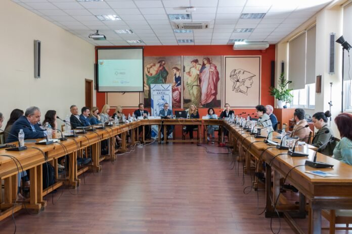 Σκηνή από τη δημόσια εκδήλωση για συμμετοχή ασθενών στο HTA με ομιλητές και κοινό στην αίθουσα